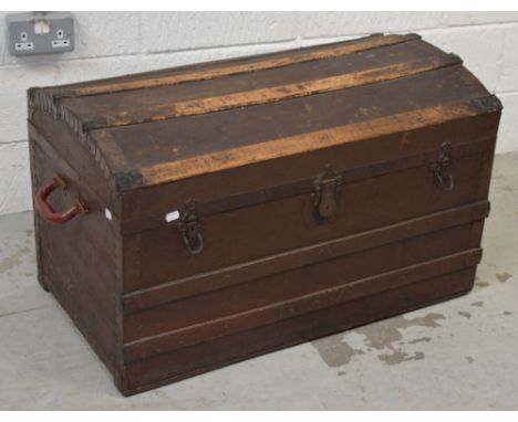 A late Victorian oak bound dome top travel trunk with iron handles, lock and riveted protective edging, approx 87 x 53cm.