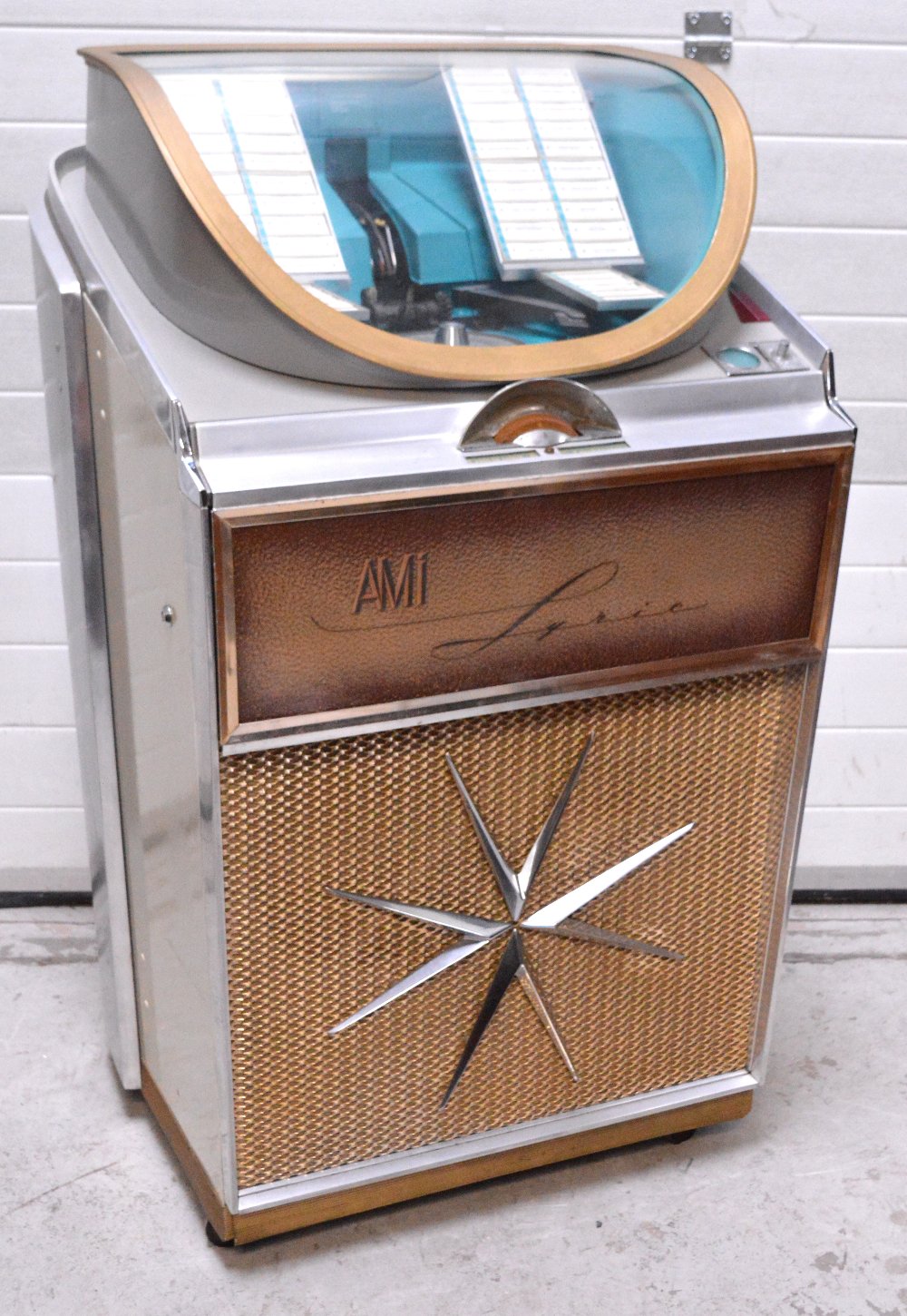 A Vintage Art Deco Ami Lyric Jukebox With Silvered And Cream Body And