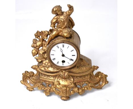 An ornate gilt metal mantel clock with figure of a young costumed boy perched on the top, the enamel dial set with Roman nume