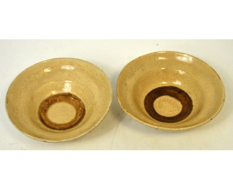 A pair of Cizhou pottery bowls of ogee form, partially covered in cream crackle glaze, the foot and central ring to the inter