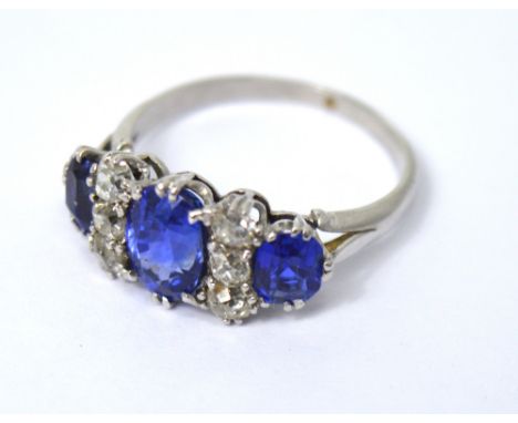 A platinum, sapphire and diamond ladies' dress ring, the largest central sapphire flanked with two rows of three diamonds and