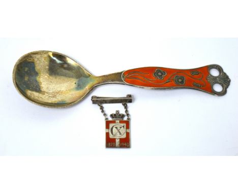 A Norwegian silver and orange enamel spoon and a silver and enamel badge commemorating the 70th birthday of King Christian of