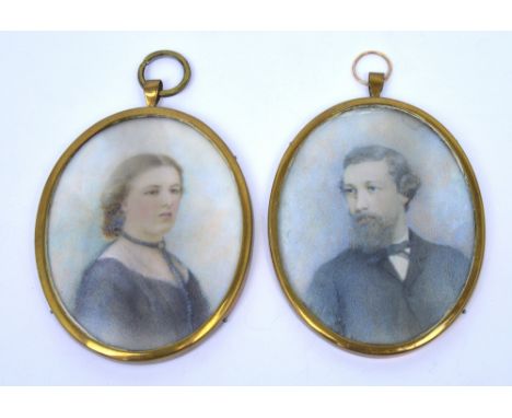 LATE 19TH CENTURY ENGLISH SCHOOL; a pair of oval portrait miniatures on ivory, a gentleman with beard and a lady wearing a be