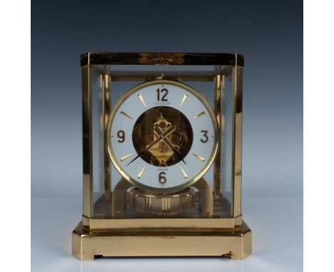 Elegant heavy table clock, gold plated in a removable glass display where all the gears are visible. Swiss made. Marked Calib