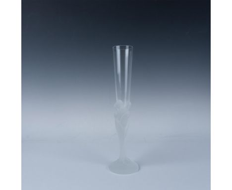 A clear glass with a frosted stem depicting the faces of seven women intertwined and flowing to the base. Erte engraved at ba