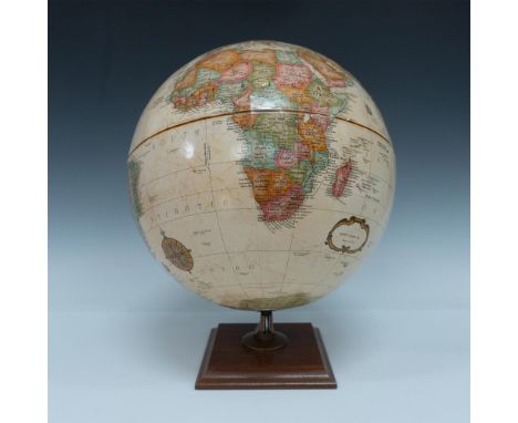 An exquisite 20th-century rotating globe featuring raised relief topography and a gold-toned meridian, elegantly complemented