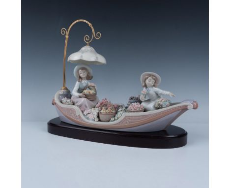 A breathtaking glossy figurine depicting two girls on a canoe, surrounded by an array of vibrant, colorful flowers. Lladro ba