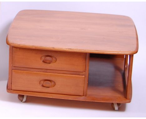 An Ercol blond elm 'Pandora's Box' coffee table, having typical curved edges, fitted with twin short drawers and open compart