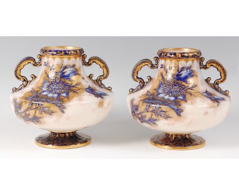 A pair of Wiltshaw & Robinson Carltonware pedestal vases, decorated with flowers in a flow-blue on a white ground heightened 