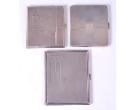A collection of three Art Deco silver pocket cigarette cases, each with stylised engine turned exteriors, two with engraved m