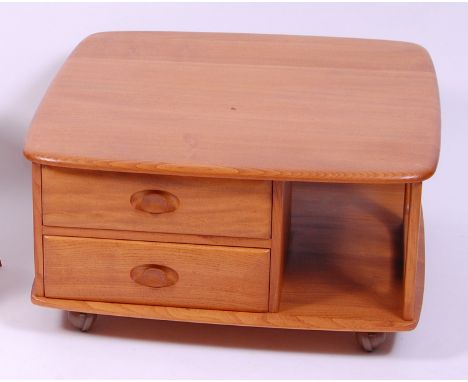 An Ercol blond elm 'Pandora's box' coffee table, having typical curved edges, fitted with twin short drawers and open compart