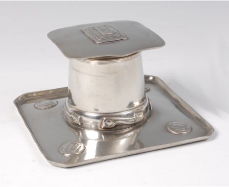 An Archibald Knox for Liberty & Co pewter inkwell, the hinged cover having raised geometric stylised floral motif, with repla