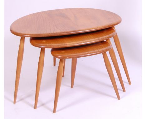 An Ercol light elm nest of three 'pebble' tables, each raised on turned supports, with label verso, largest h.40cm, w.65cm, d