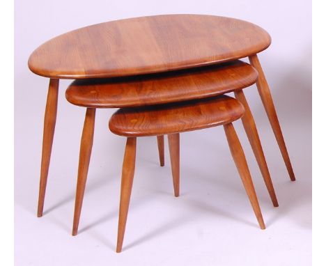 An Ercol light elm nest of three 'pebble' tables, each raised on turned supports, probably originally mid colour, h.40, w.60,