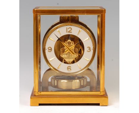 A Jaeger LeCoultre lacquered brass Atmos clock, the white dial stamped Jaeger LeCoultre Atmos Swiss Made, within glazed case,