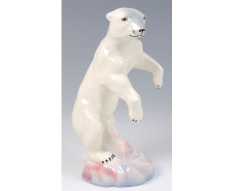 A Czechoslovakian Art Deco glazed ceramic figure of a polar bear, standing on its hind legs, on integral rocky outcrop, under