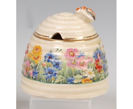 A 1930s Clarice Cliff pottery honey-pot and cover, of honeycomb ribbed form, the cover with bee handle, the base decorated wi
