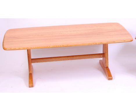 A contemporary Ercol blond elm round cornered coffee table, of good size, raised on curved end supports united by central str