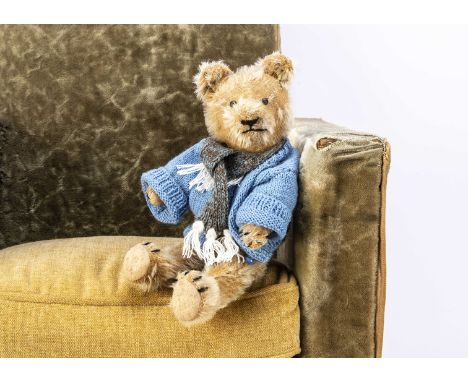 A 1920s teddy bear,  probably British with short blonde mohair, black tinplate eyes, pronounced muzzle, black stitched nose, 