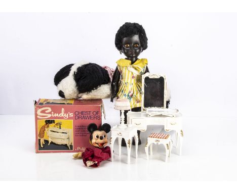 An English rubber head black doll,  in a floral dress --16½ in(42cm.) high (missing earring), a Sindy chest of drawers in ori