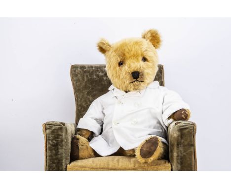 A post-war Chiltern Hugmee teddy bear,  with golden mohair, orange and black glass eyes, pronounced muzzle, black stitched no