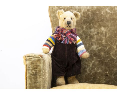 A 1930s British teddy bear,  with light golden mohair, orange and black glass eyes, pronounced muzzle, black stitched nose an