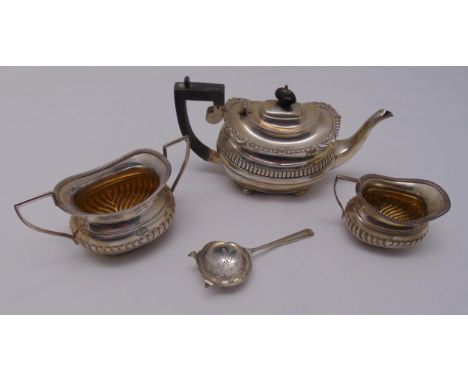 A hallmarked silver teapot, sugar bowl, cream jug and a tea strainer, approx total weight 699g