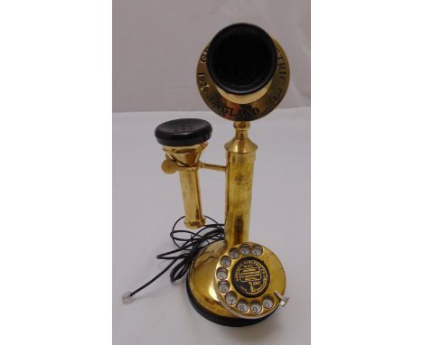 A gilded metal stick telephone of customary form on raised circular base, 32cm (h)