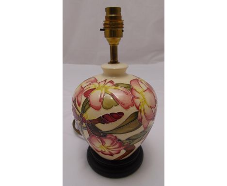 A Moorcroft baluster form table lamp decorated with flowers and leaves on circular wooden base, 29cm (h)