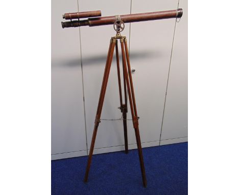 An antique brass and leather bound telescope on brass mounted wooden tripod stand