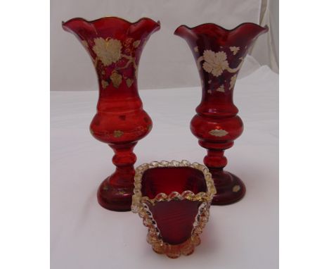 A pair of Victorian ruby glass vases, vine leaf decoration on raised circular bases and a ruby red vase of tapering rectangul