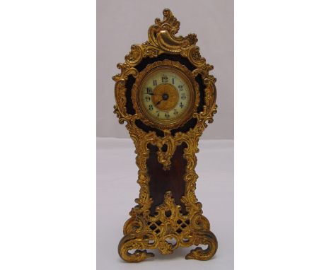 An early 20th century desk clock shaped oval form with applied gilded metal mounts white enamel chapter  ring with Arabic num