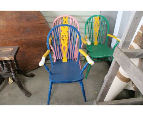 Three painted stick and wheelback elbow chairs