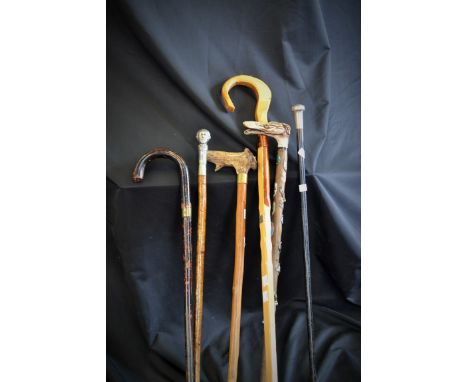 A gentleman's silver topped ebonised walking cane; a sword stick; a walking cane with handle modelled as a gentleman's head; 