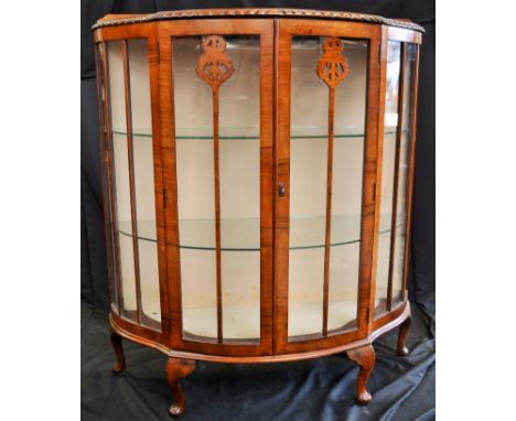 A mahogany glass cabinet with light inside that has a modern plug