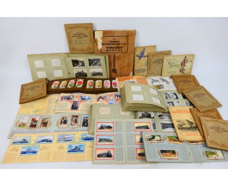 A collection of cigarette card albums to include railway, aviation, flora, sights of Britain and other, also includes a Morri