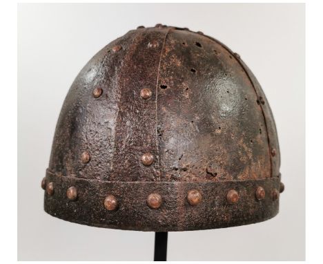 Ca. 900 - 1000 AD. A helmet fabricated from four triangular iron plates curved to conform to the human head; riveted construc