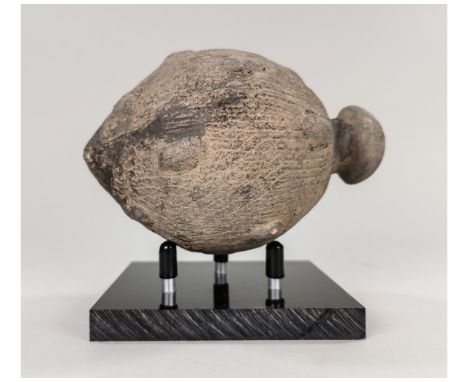 Ca.800 AD. A hollow ceramic Vessel with a barrel-shaped body, domed top, and conical base, knop to the upper face for the mou