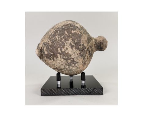 Ca.800 AD. A hollow ceramic Vessel with a barrel-shaped body, domed top, and conical base, knop to the upper face for the mou