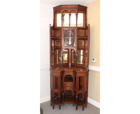 A Victorian walnut corner display cabinet, the upper section enclosed cupboard and open shelves with bevelled mirror and glas