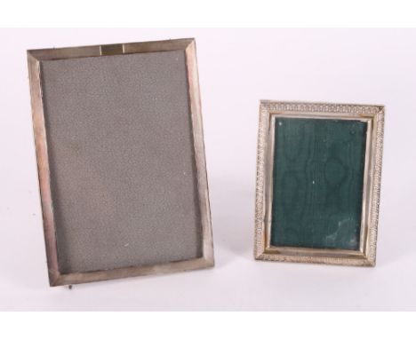A silver photograph frame with engine turned decoration and a smaller similar with laurel leaf decoration