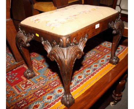 A carved mahogany dressing stool of mid Georgian design, on acanthus leaf and cabriole claw and ball supports, 23" wide