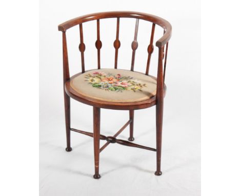An Edwardian polished as walnut tub shape open armchair with splat back and tapestry seat