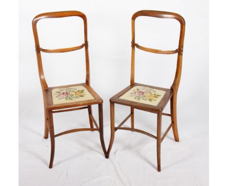 A pair of late 19th Century rosewood "deportment" chairs with drop-in tapestry panel seats, on turned and stretchered support
