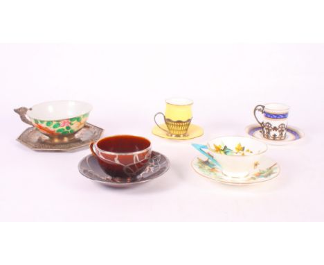 A Staffordshire brown glazed teacup and saucer with silver mounts and two bone china coffee cups and saucers with silver hold
