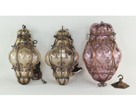 THREE VENETIAN GLASS & METAL FRAMED HALL LANTERNS, comprising a pair in smoky glass, 30cms high, and a larger amethyst glass 