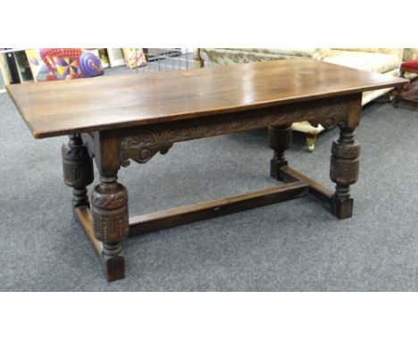 ELIZABETHAN-STYLE OAK REFECTORY TABLE, boarded top above channel carved frieze with scrolled brackets, raised on carved cup a