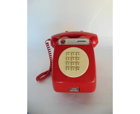 A vintage red Bakelite cased payphone unit bearing metallic plaque with '20 cents' aperture and instructions for use, with bu