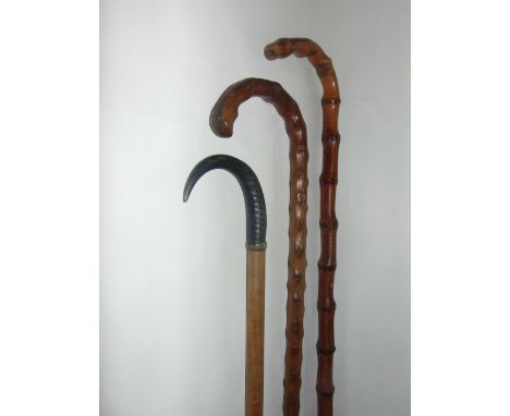 An antique timber walking cane terminating in an applied horn handle, a further bamboo example and a Thornwood walking stick 