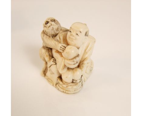 A late 19th/early 20th century Japanese ivory netsuke of a seated man and playful monkey, 4 cm